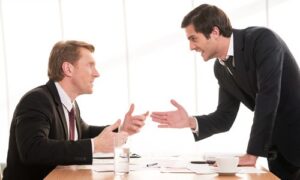 business-conflict-two-young-men-formalwear-arguing-gesturing-while-sitting-table