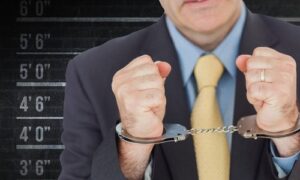 composite-image-closeup-businessman-with-handcuffed-hands